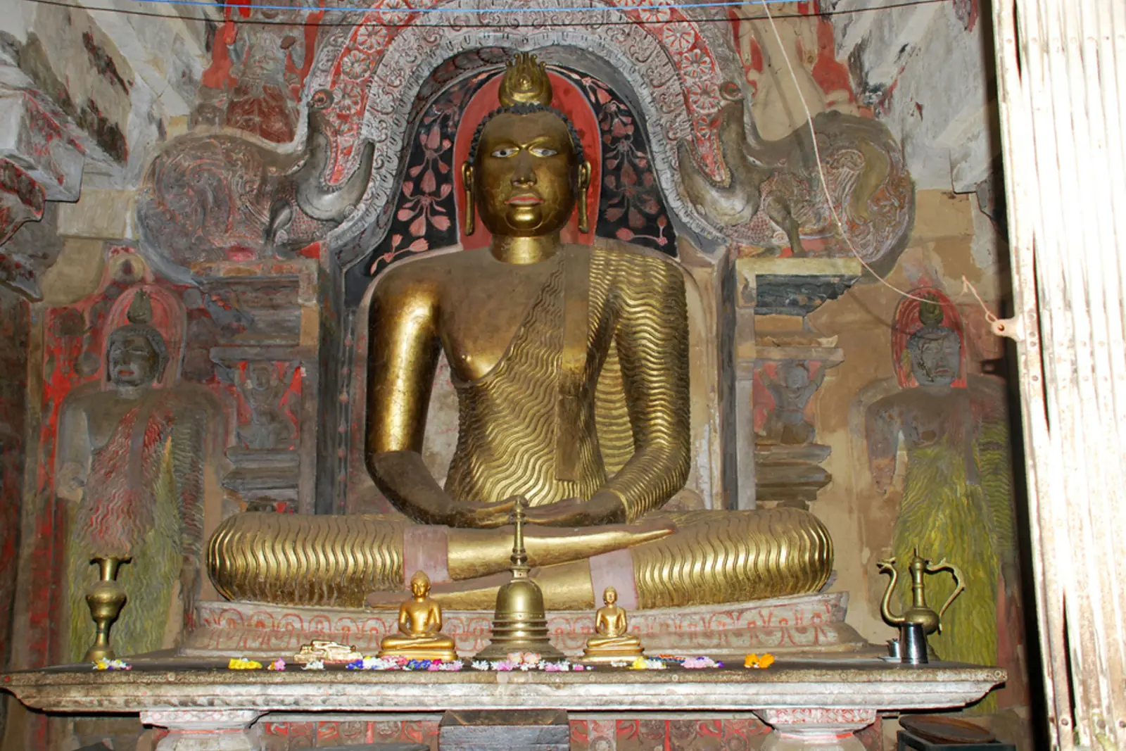 Goldene Buddha-Statue in einer historischen Tempelanlage in Kandy, Sri Lanka